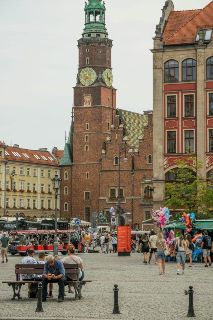 Bustling market square in Wrocław with Town Hall and people enjoying the day.
