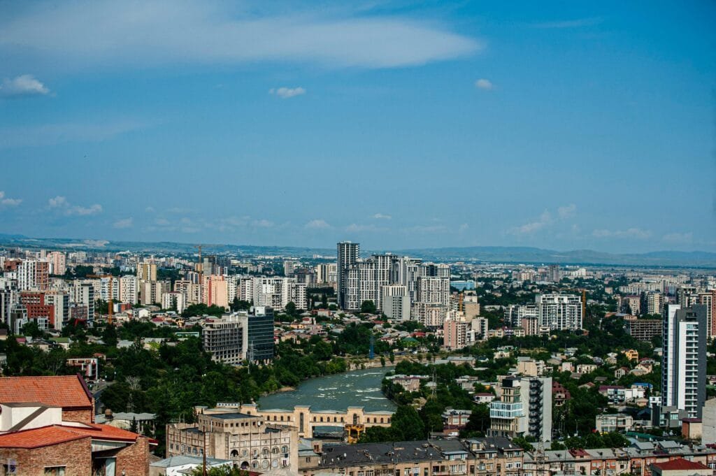 Discover the vibrant urban skyline of Tbilisi, Georgia's capital, under a clear blue sky.