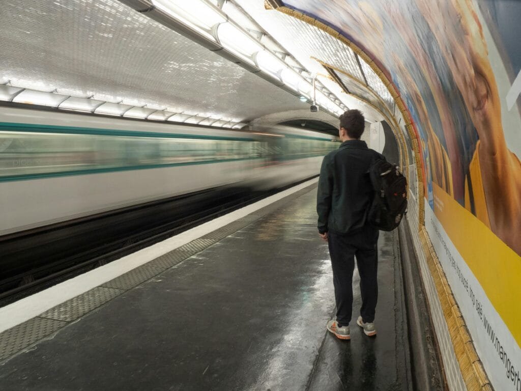 A person waits on a platform as a train speeds by in a Paris metro station.¿Cuándo debo contratar un seguro de cancelacion exactamente?