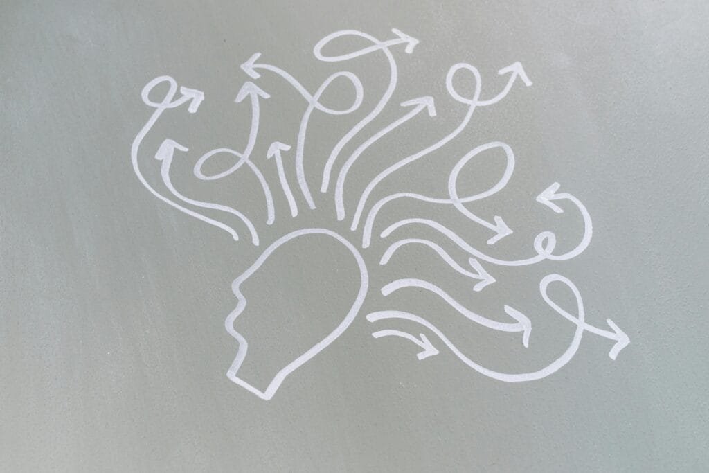Chalk drawing of a head with swirling arrows represents mental activity and thought process.La Salud mental se puede alterar al viajar solo