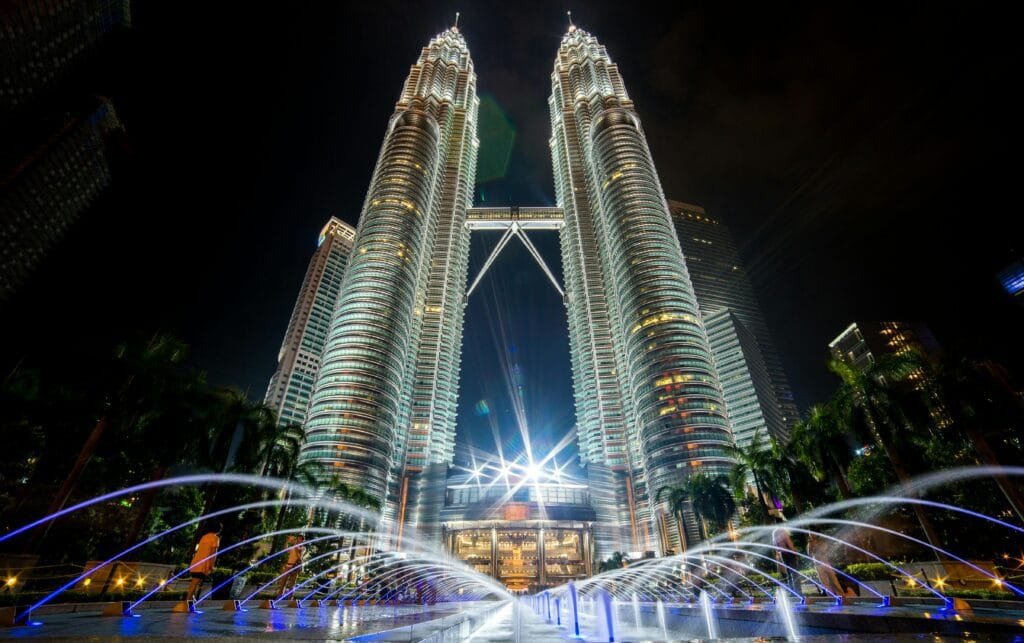 Stunning night view of the illuminated Petronas Twin Towers in Kuala Lumpur with fountains in the foreground.¿Cómo ir de Kuala Lumpur a Phuket barato y fácil?